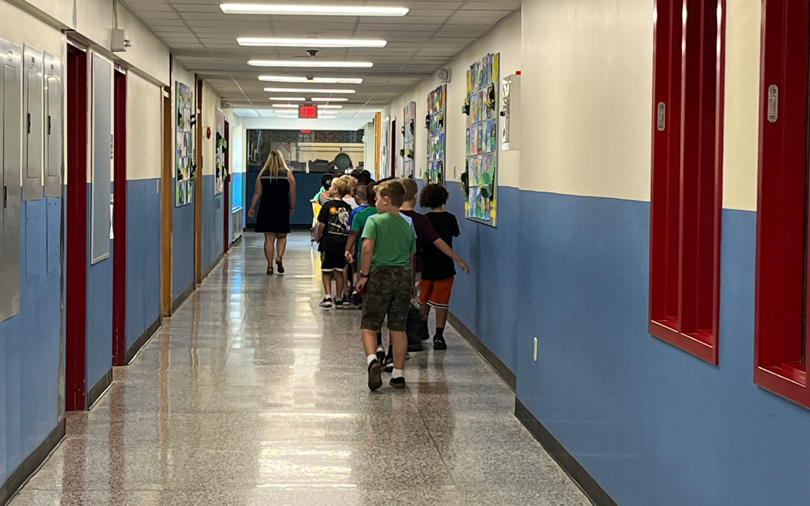 Elementary School student gets his hand painted during classroom art activity.