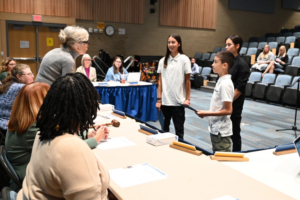 An image of North Colonie Board of Education President Linda Harrison addressing the Miracle siblings.