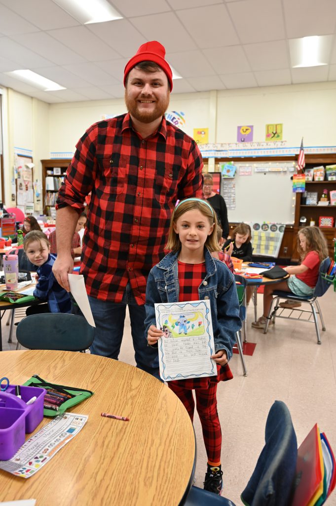 An image of Paul Bunyan standing next to a student dressed in flannel like him.