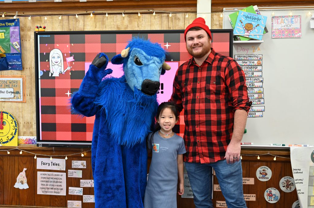 An image of Paul Bunyan and Babe the Ox posing with a student.