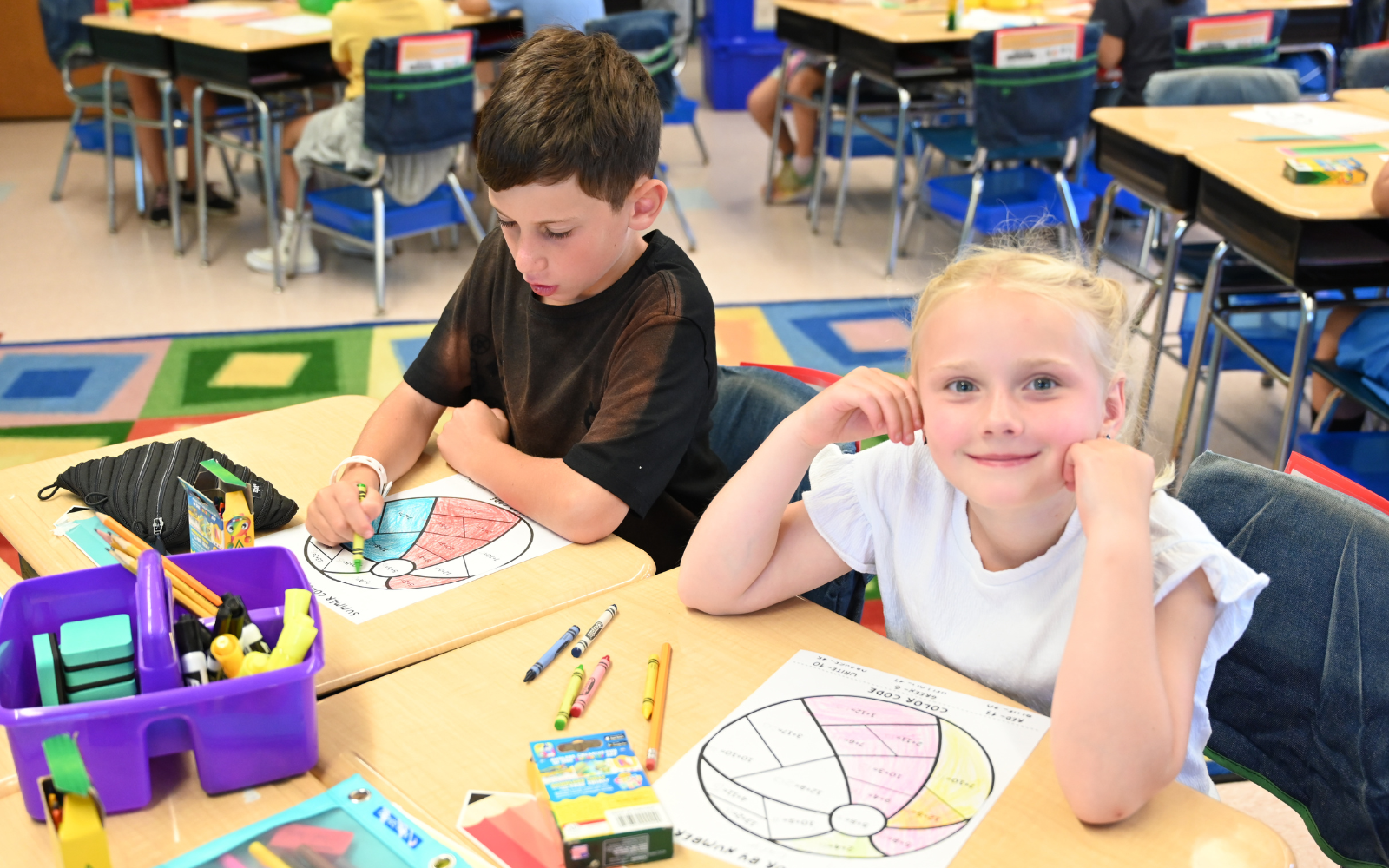 Elementary School student gets his hand painted during classroom art activity.