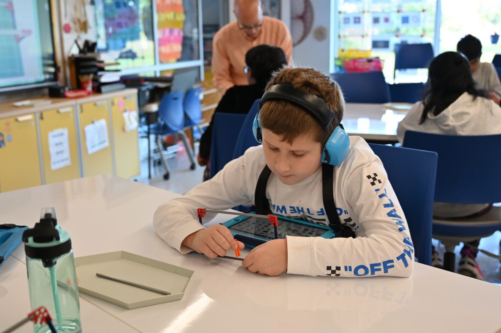 An image of a student working individually to build a structure using K'nex.