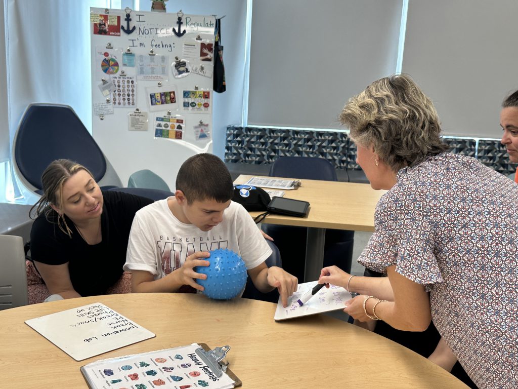 An image of a teacher working with a student on an exercise.