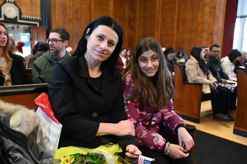 An image of a woman and her daughter posing in a courtroom.