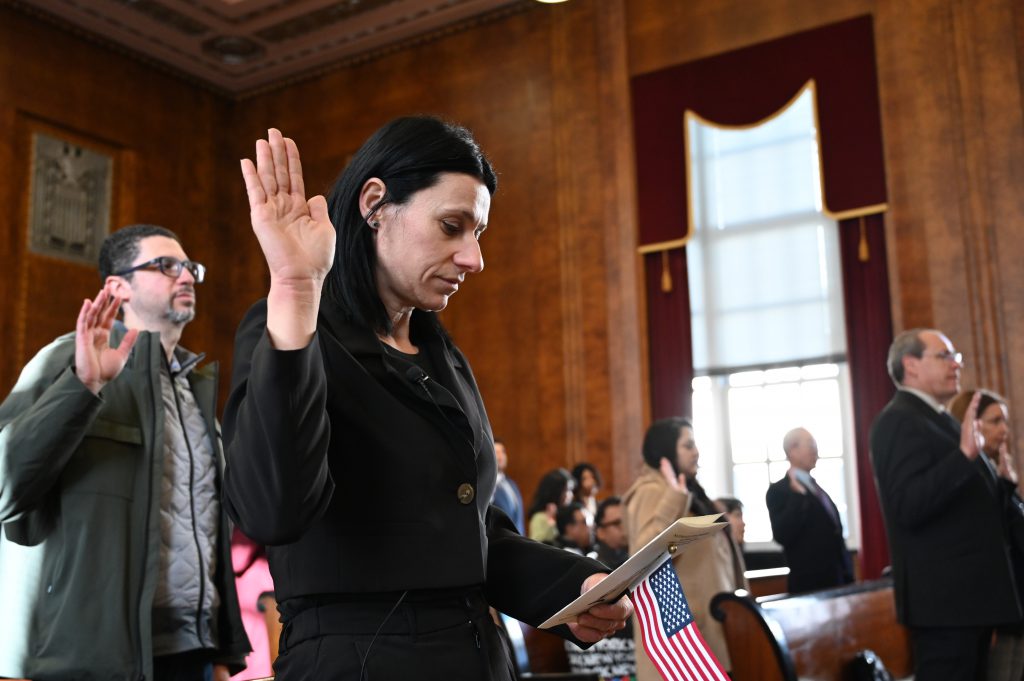 An image of a woman raising her right hand.