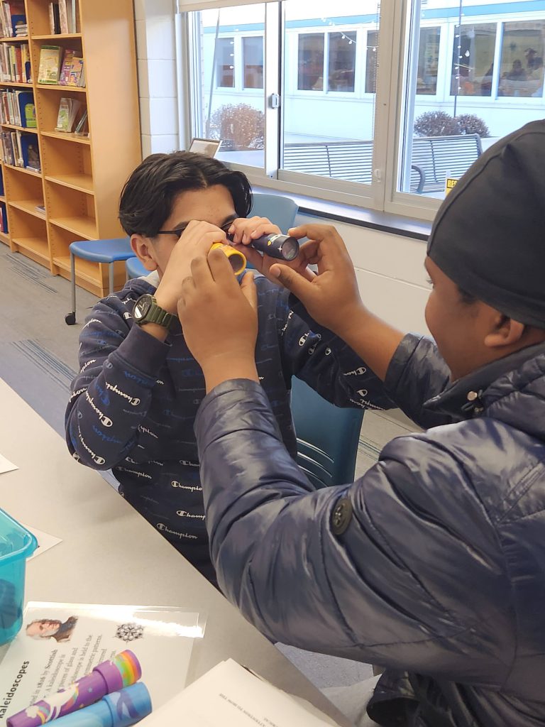 An image of two students comparing kaleidoscopes.