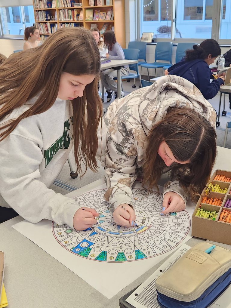 An image of two students coloring mandalas.