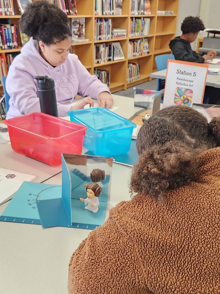 An image of students learning about reflective art hands on.