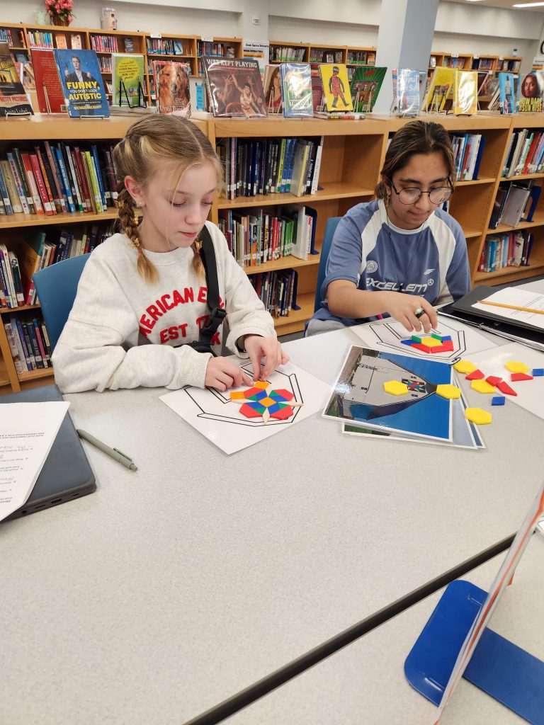 An image of two students creating barn quilts out of balsa blocks.