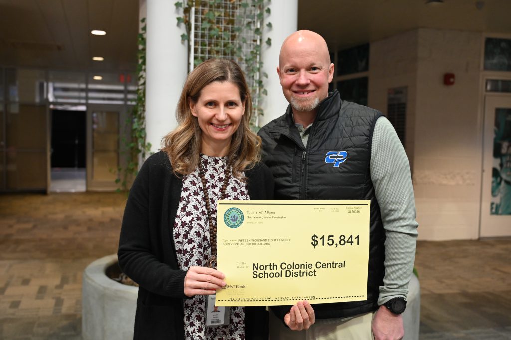 An image of two people holding a grant check.