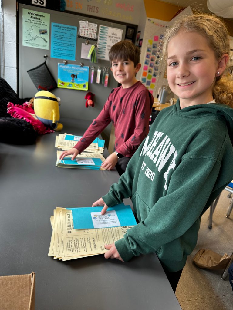 An image of two students collecting handmade birthday cards.