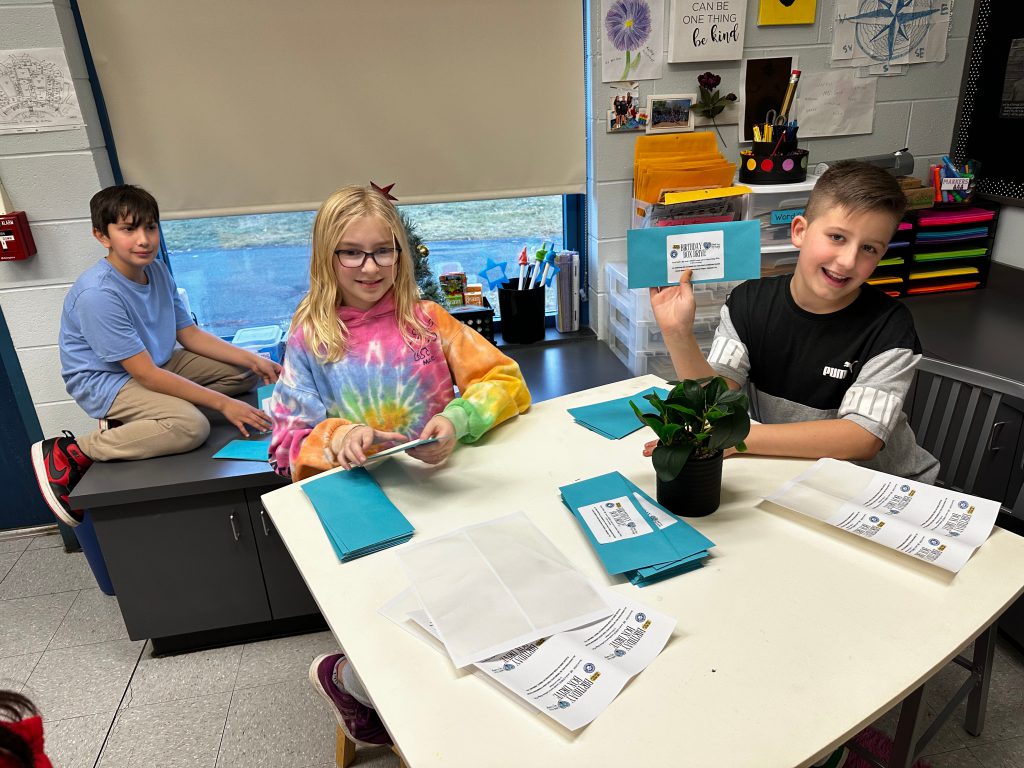 An image of three students creating handmade birthday cards.