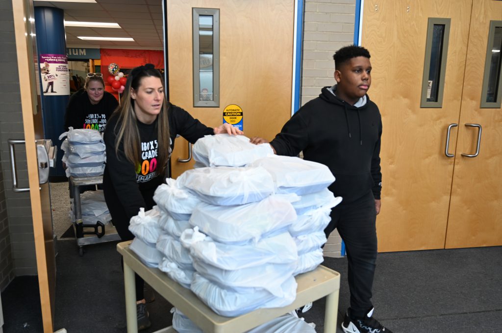 An image of a student and teacher carting birthday boxes.