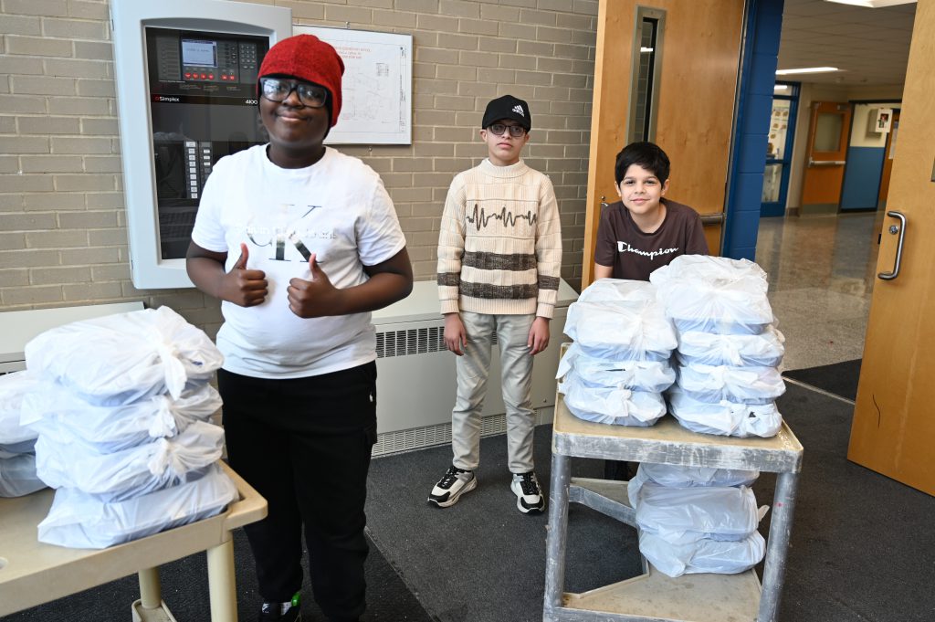 An image of students carting boxes out of the school building.