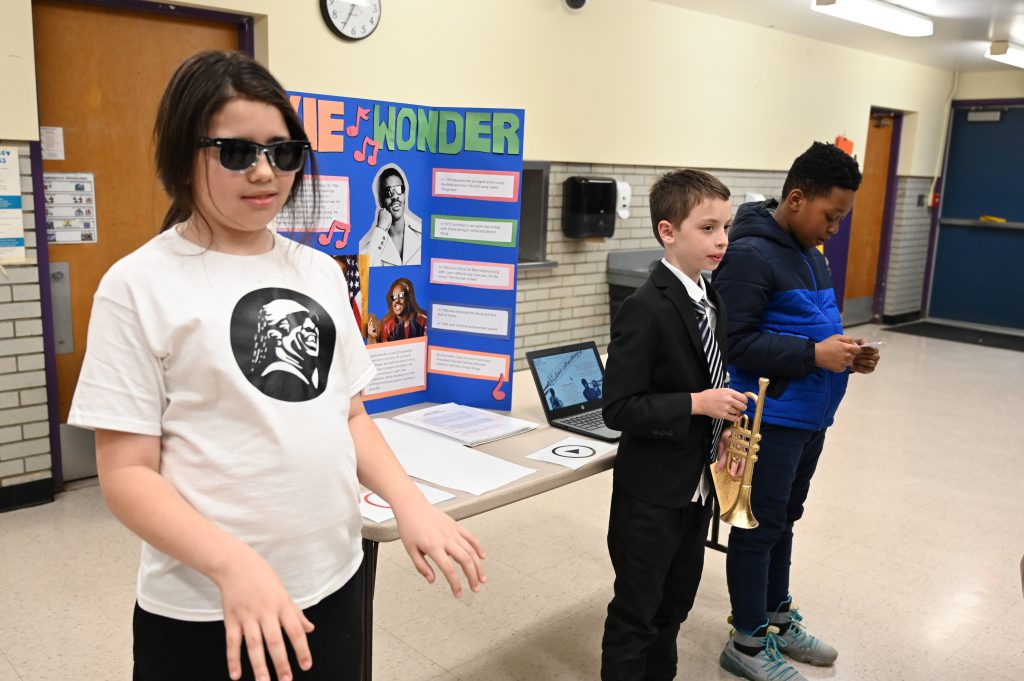 An image of several students posing as they wait to someone to engage them in a presentation.