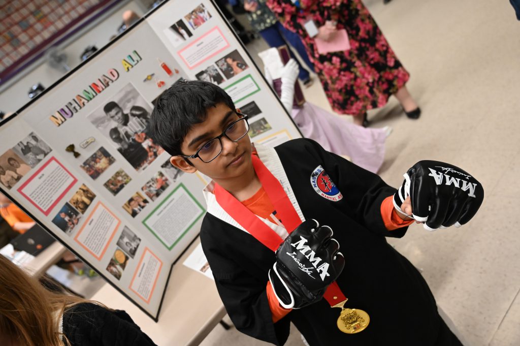 An image of a student dressed up as a boxer as he plays the role of Muhammed Ali.