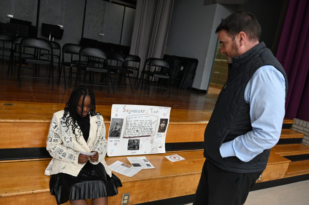 An image of a student playing the role of Sojourner Truth as an adult listens on.