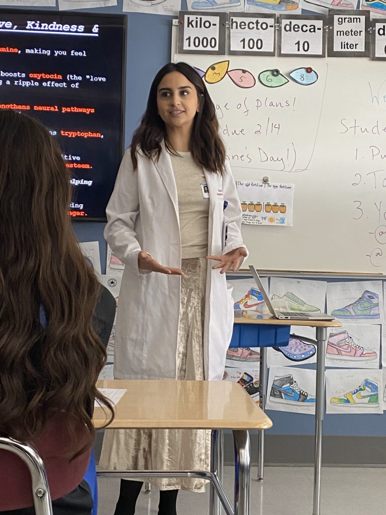 An image of a doctor standing at the front of a classroom.