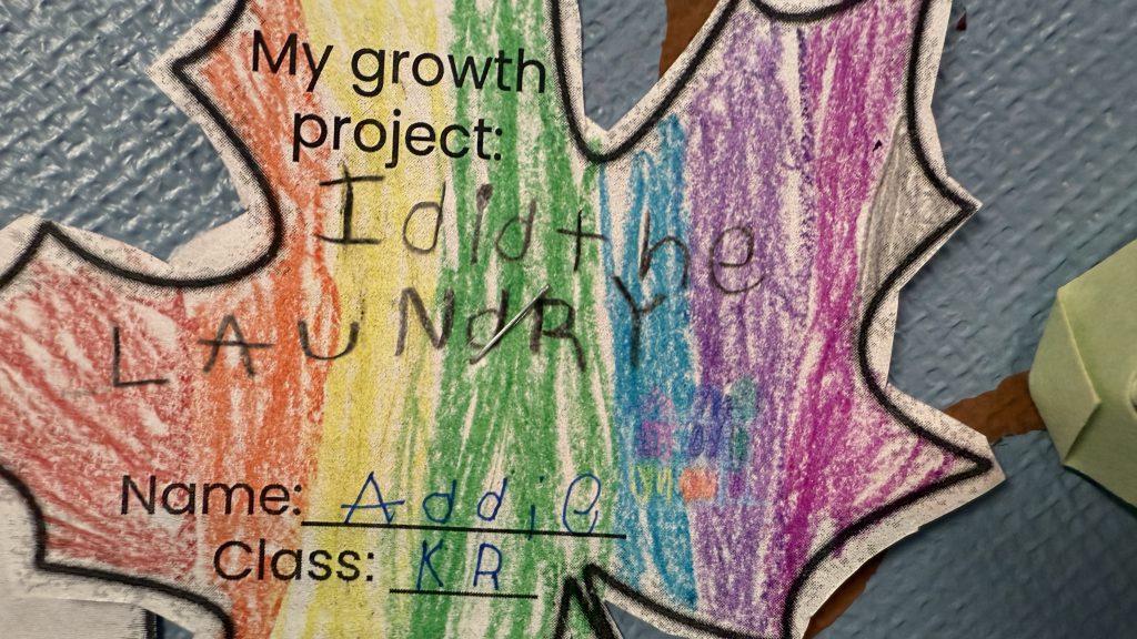 An image of a piece of paper colored with crayons that says, "I did the laundry."