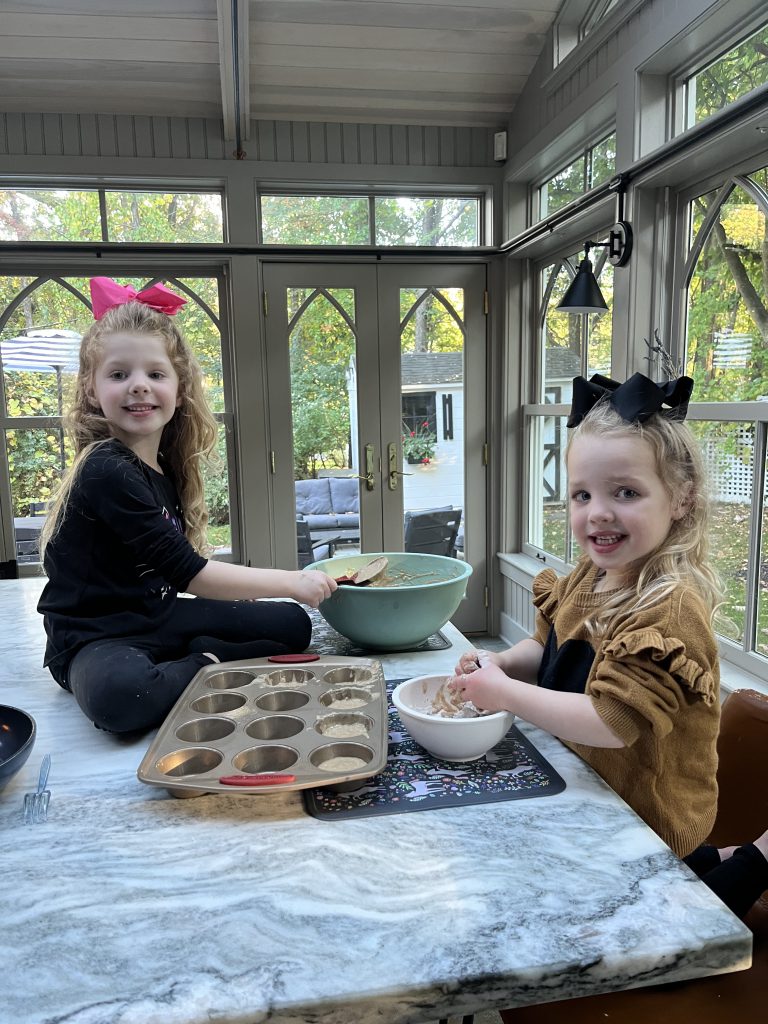 An image of two children baking at an island.