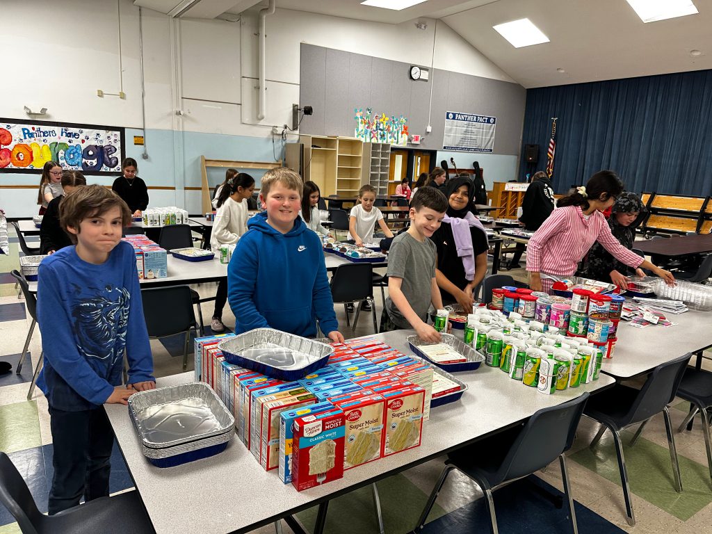 An image of students sorting items on a table.