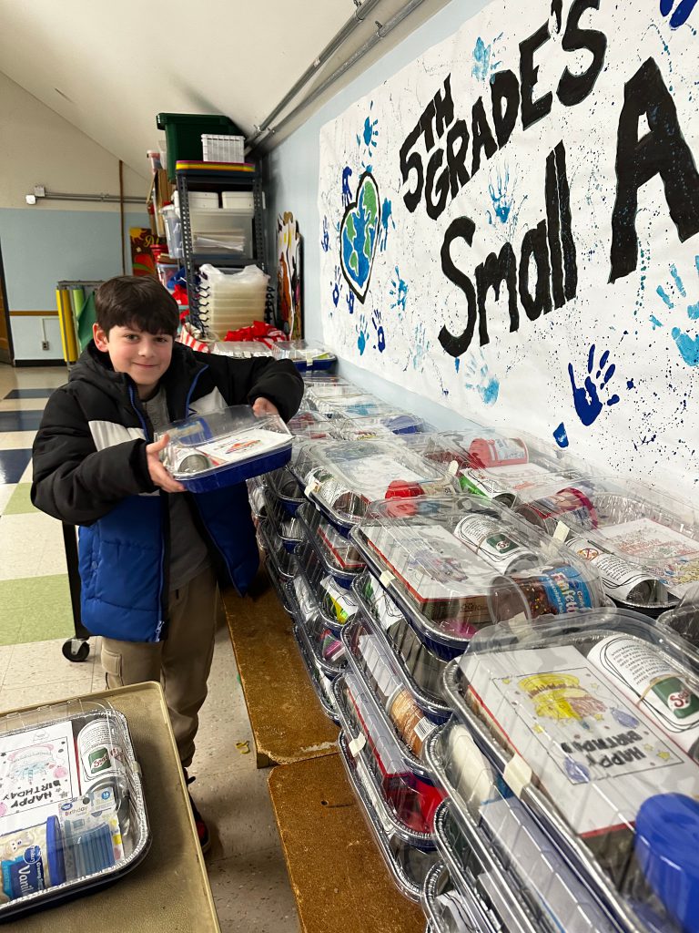 An image of a student stacking birthday boxes on a table.