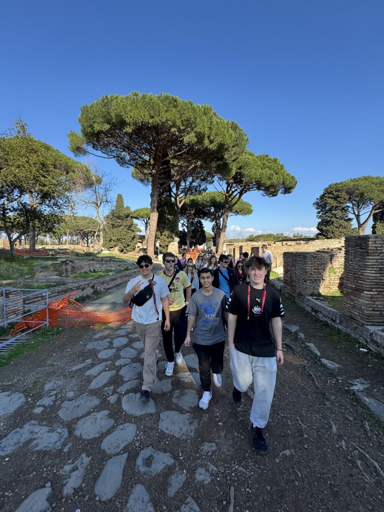 An image of students on a stone path with trees behind them in Italy.